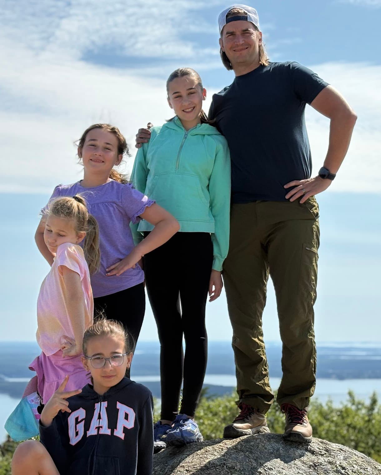 Nick Paul and family on a mountain summit overlooking the water